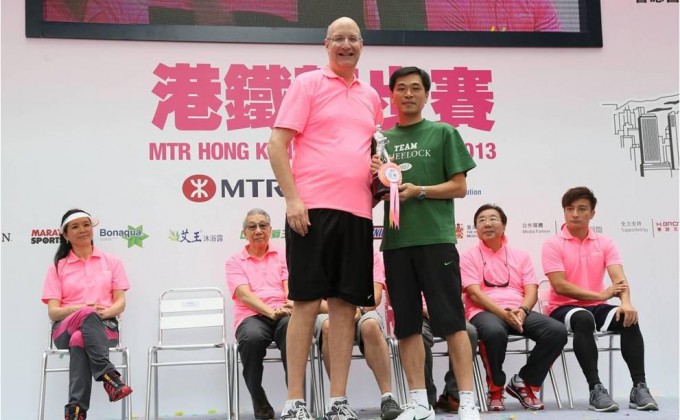 會德豐地產常務董事黃光耀先生(右)從港鐵公司行政總裁韋達誠先生(左)手中接過最高籌款公司獎亞軍獎盃。 
