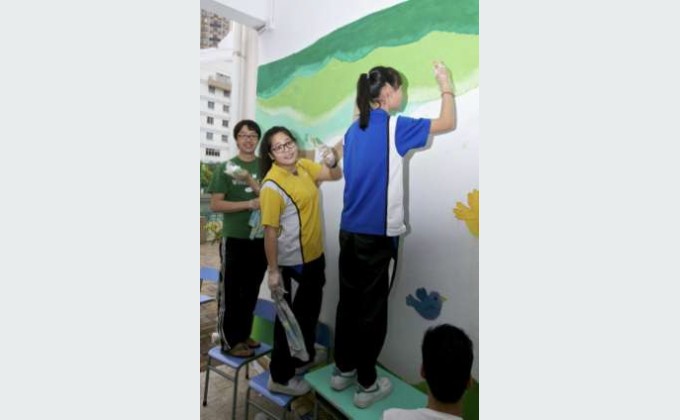 各义工及同学细心绘画壁画，美化校园。