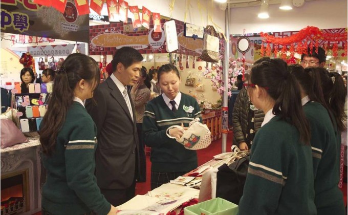 「凤溪第一中学」的学生向会德丰地产常务董事黄光耀先生(左二)推介环保袋。
