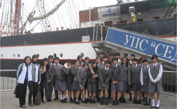 会德丰地产义工与「五育中学」的师生在最大古帆船「谢多夫」号（Sedov）前合照。
