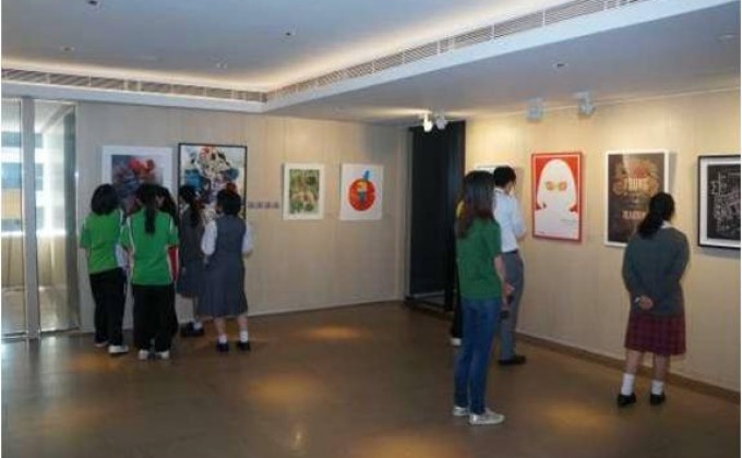 會德豐義工與「五育中學」的同學一同觀賞展出的藝術作品。
